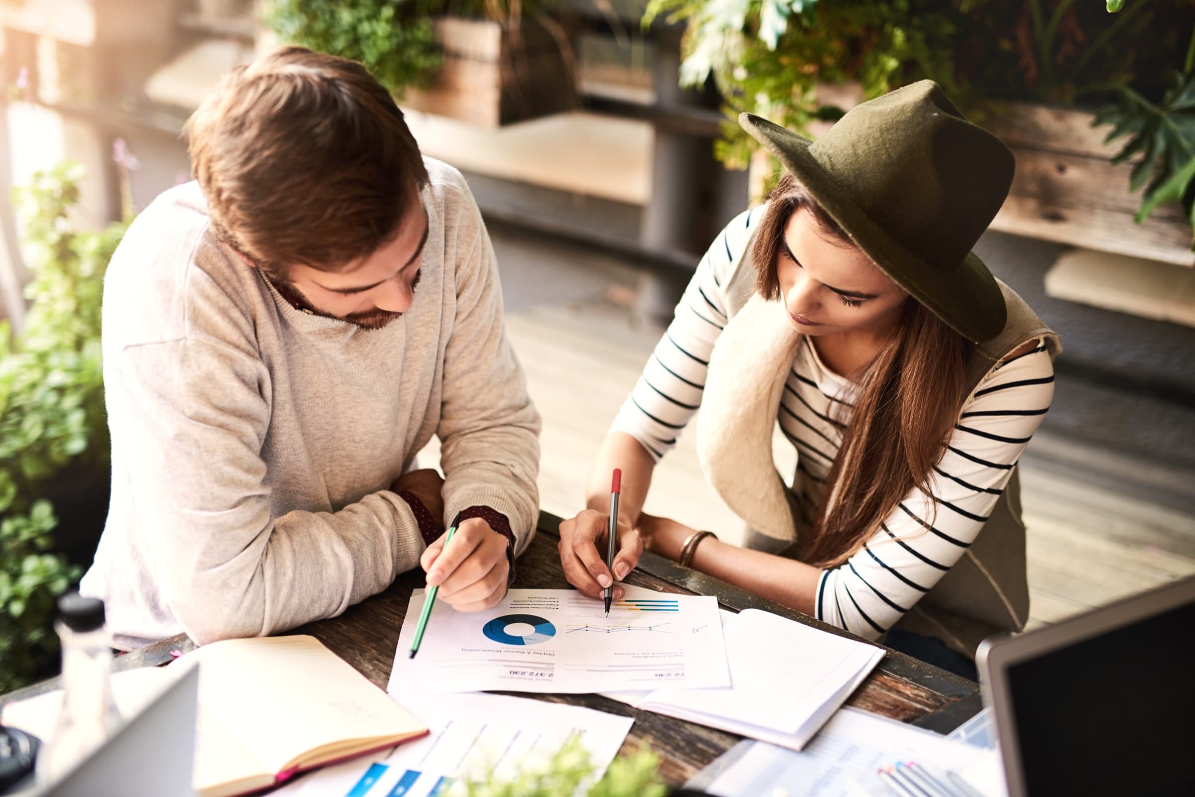 Two people reviewing business charts together at an outdoor table